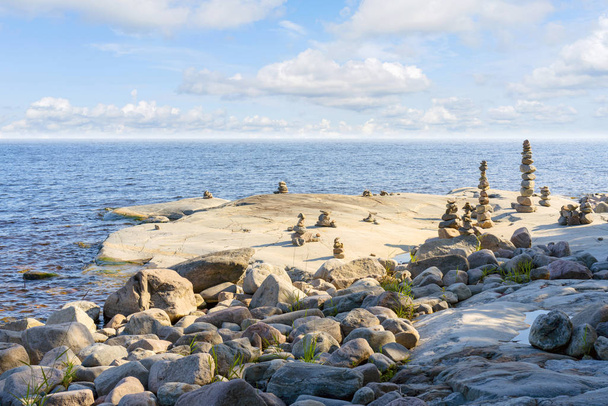 Gestapelde rotsen balanceren, stapelen met precisie. Stenen torens aan de kust - Foto, afbeelding