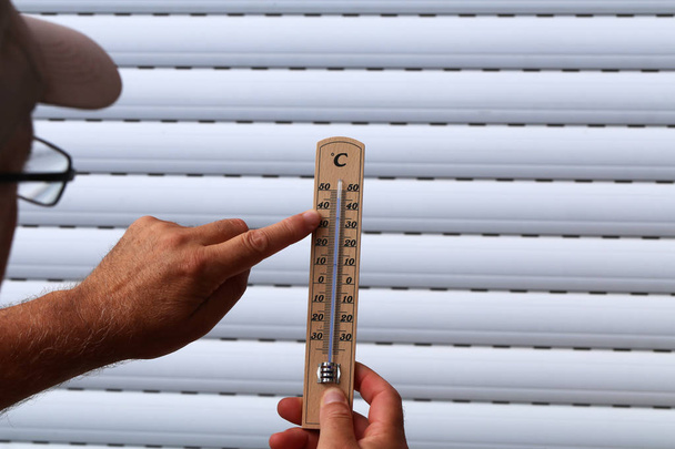 Hot Summer - Thermometer in hand, shows the heat - Φωτογραφία, εικόνα