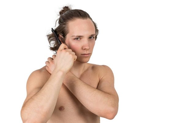 Naked handsome young man combing his hair on white background isolated - Foto, Imagen