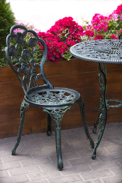 Kovácsoltvas asztal és székek a kertben - Fotó, kép