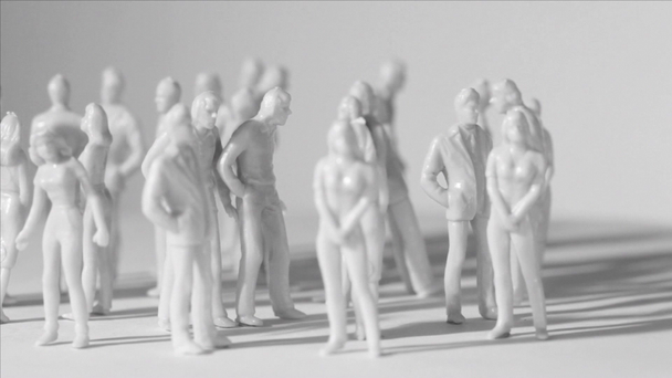 Ryhmä pieniä maalaamattomia leluja miehet ja naiset seisovat ja pudottavat varjoja
 - Materiaali, video