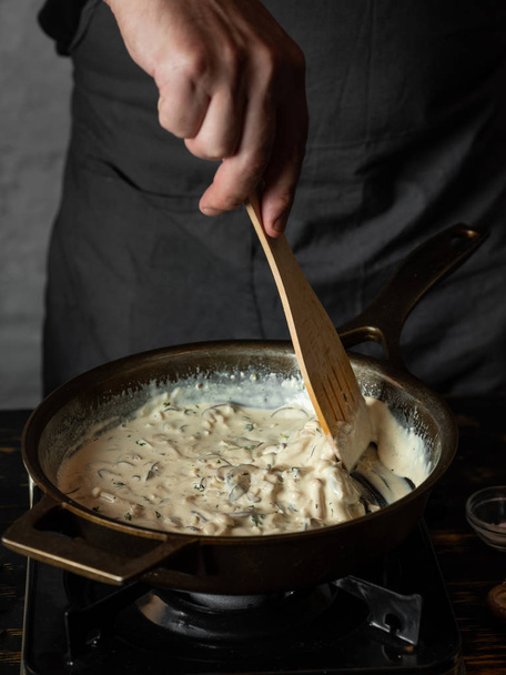 Close view of chef cooking creamy mushroom sauce with spices and rosemary in pan - Foto, immagini