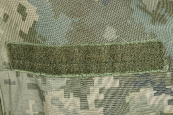  velcro verde sobre ropa militar manchada
 - Foto, Imagen