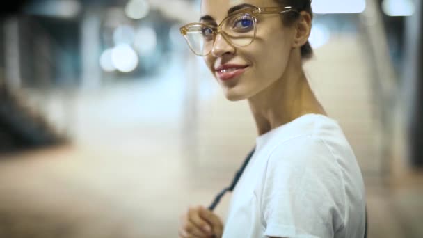 close-up portrait of young smiling fashionable beautiful woman in transparent eyewear posing outdoors. slow motion - Filmati, video