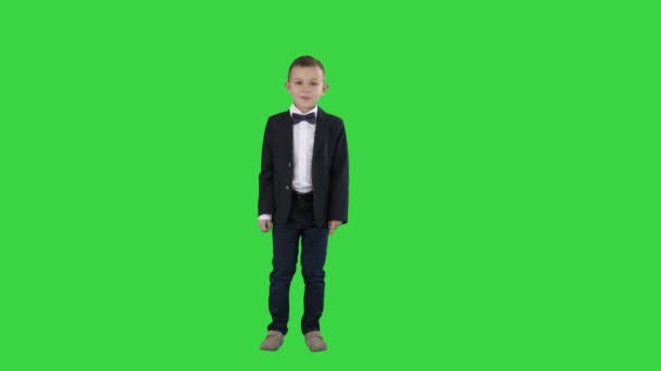 Takım elbiseli çocuk bir çerçeve içinde yürür ve Yeşil Ekranda konuşmaya başlar, Chroma Key. - Video, Çekim