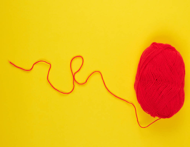 big skein of red wool on a yellow background - Foto, imagen