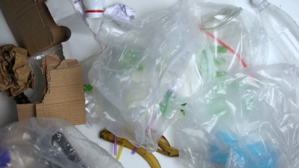 Σκουπίδια που βρίσκονται γύρω από την αποθήκευση της φράσης του πλανήτη ενάντια στο λευκό φόντο οικολογία - Πλάνα, βίντεο