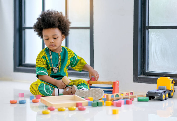 African young boy has fun with playing various type of toys. - Zdjęcie, obraz