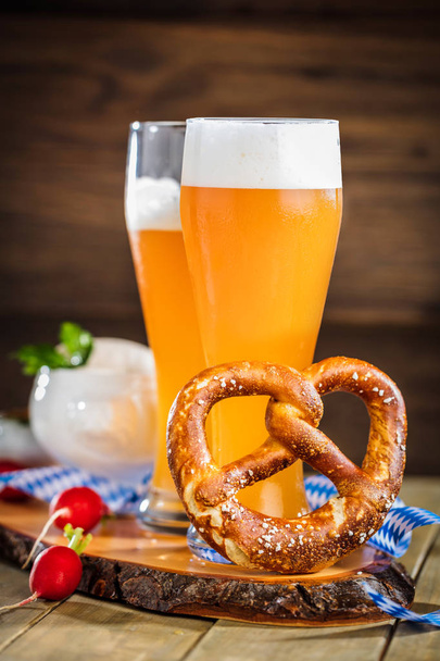 glasses of beer, pretzel and fresh radishes on wooden table - Φωτογραφία, εικόνα