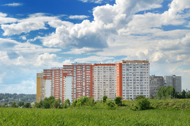 Современный 17-этажный желто-оранжевый дом в зеленой зоне недалеко от Мо
 - Фото, изображение