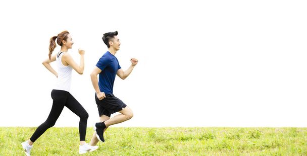boční pohled na mladé dvojice, běžící na trávě - Fotografie, Obrázek