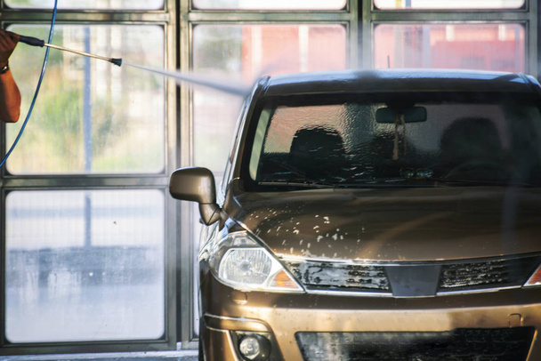 personne lavant sa voiture sur une station avec un nettoyeur spécial, services de lavage de voiture
 - Photo, image