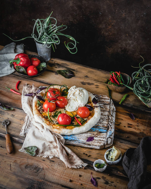 Házi pizza sült paradicsommal gasztra és Burrata sajttal, fadobozon  - Fotó, kép