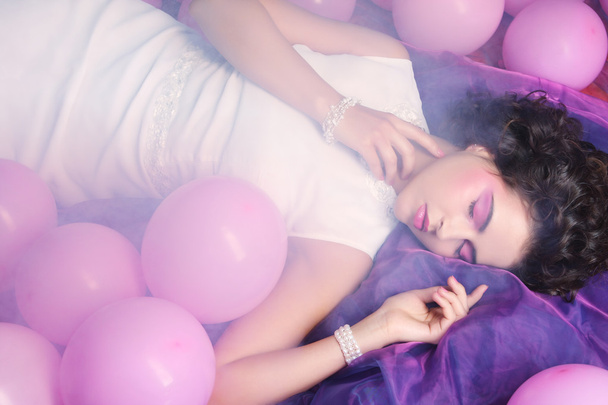 Sleeping woman lying on floor among balloons - Фото, зображення