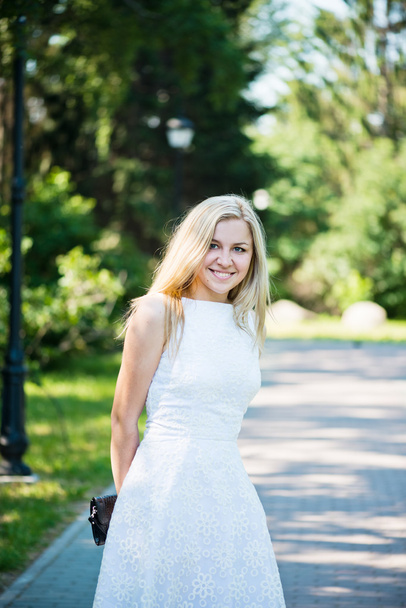 Beautiful young blond woman in a white dress outdoors - Fotografie, Obrázek