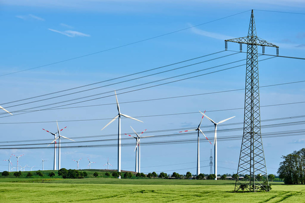 Wind wheels and power lines in a corn field in rural Germany - Fotoğraf, Görsel