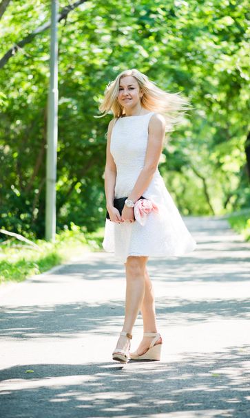 Beautiful young blond woman in a white dress outdoors - Foto, immagini