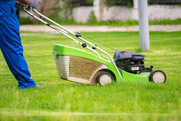 Bahçe çim tarlalarında biçme makinesi ile bahçıvan işçi kesme çim - Fotoğraf, Görsel