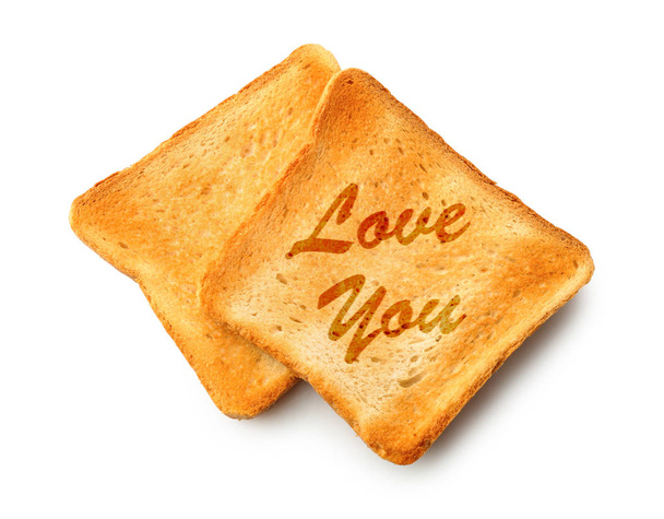 Toasted bread with inscription LOVE YOU on white background - Photo, Image