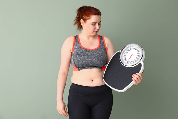 Mulher com excesso de peso com escalas no fundo de cor. Conceito de perda de peso
 - Foto, Imagem