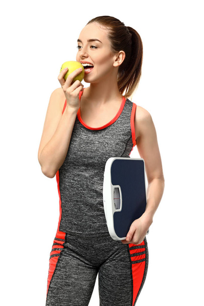 Νεαρή γυναίκα με μήλο και λέπια σε λευκό φόντο. Έννοια απώλειας βάρους - Φωτογραφία, εικόνα