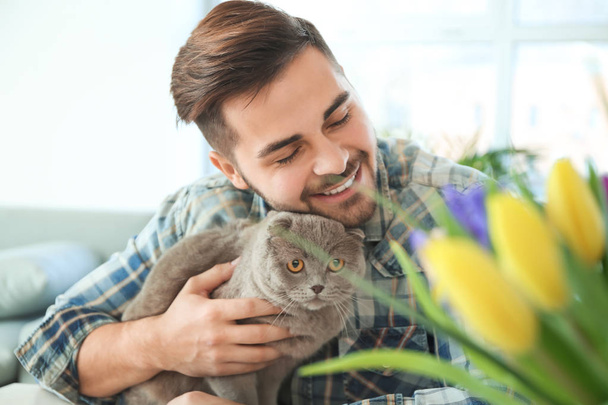 Giovane uomo con simpatico gatto divertente a casa
 - Foto, immagini