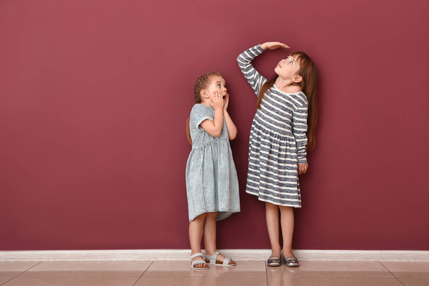 Kleine Mädchen messen Höhe in der Nähe der Mauer - Foto, Bild