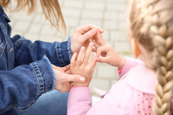 Mère enseignant à sa fille sourde et muette à utiliser le langage des signes à l'extérieur
 - Photo, image