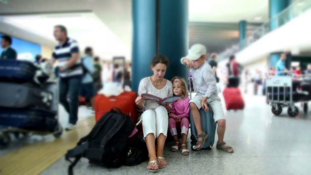 Anya és a gyerekek ülnek repülőtér és olvasókönyv - Felvétel, videó