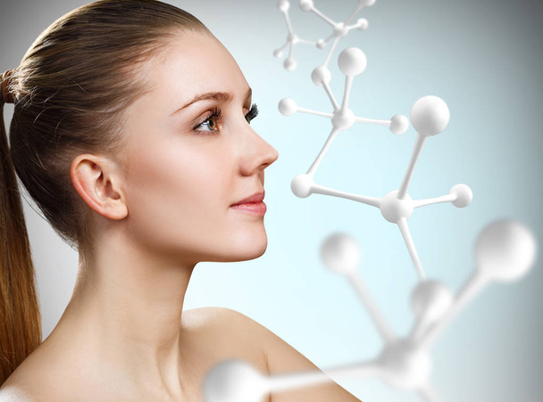 Красива жінка біля великої структури білої молекули
. - Фото, зображення