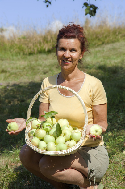 Donna sorridente che mostra mele biologiche
 - Foto, immagini