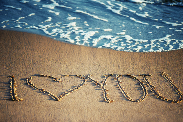 Ti amo - scritto sulla sabbia con un'onda schiumosa sotto
 - Foto, immagini