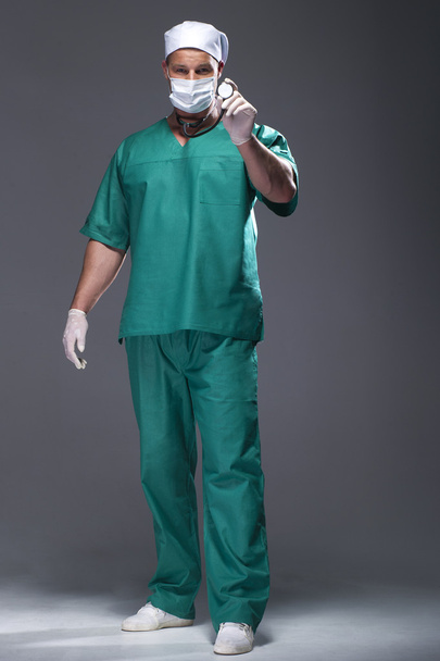 Caucasian mid adult male doctor wearing a mask - Фото, зображення