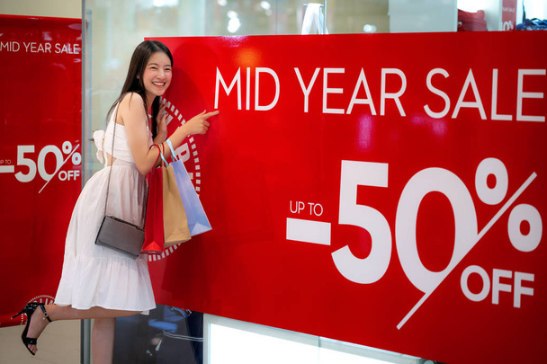 中間年セールでアジアの女の子の買い物 50 パーセンオフプロモーション - 写真・画像