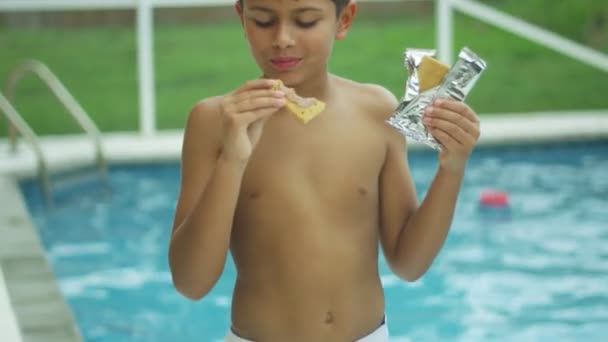 Bir yüzme havuzunun önünde kamera gülümsüyor iken yeme genç bir çocuğun yavaş hareket - Video, Çekim