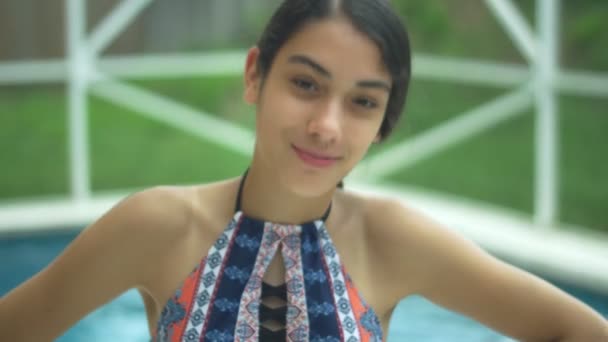 Young girl with braces smiling at camera by the pool - Video