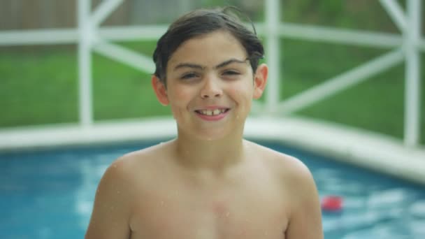 carino ragazzo sorridente a il fotocamera mentre in piedi di fronte un piscina in costume da bagno
 - Filmati, video