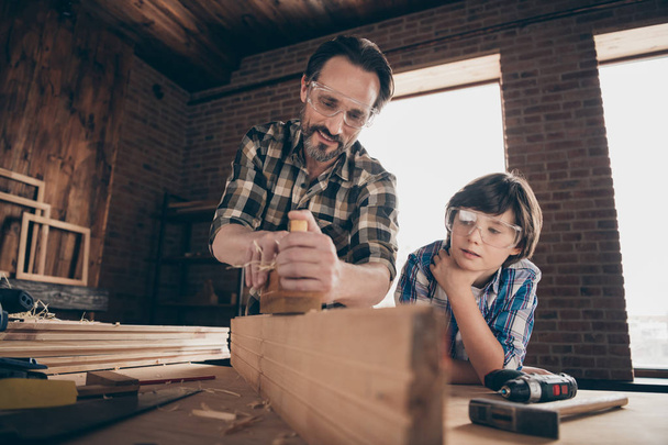 Close up photo of charming nice attractive people person adult child have construction repair shop hardwood glasses shirt plaid trendy stylish generation indoors workstation glasses goggles protective - 写真・画像