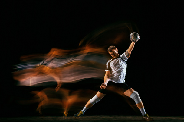 Young handball player against dark studio background in mixed light - Zdjęcie, obraz