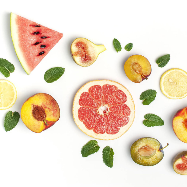 Tropical Summer Fruit Concept. Creative layout made of fresh ripe watermelon, peach, plum, fig, lemon, grapefruit and mint leaves on white background. Flat lay, top view, copy space. Food background - Φωτογραφία, εικόνα