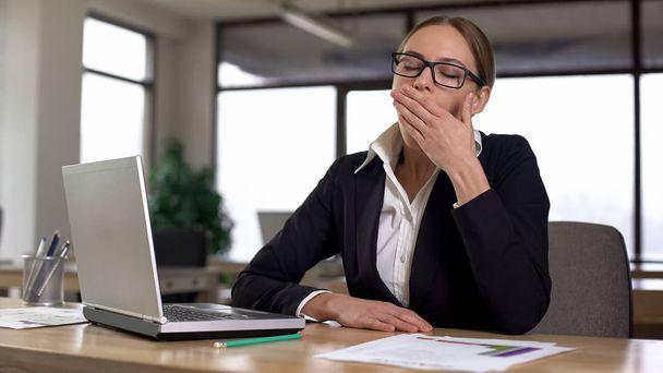 Donna sbadigliare mentre lavora sul computer portatile, stanco di lavoro monotono in ufficio
 - Foto, immagini