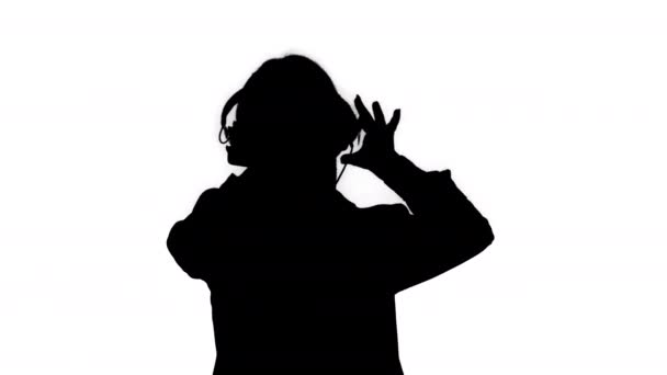 Silhouette Young business woman listening to music in headphones and dancing. - Záběry, video