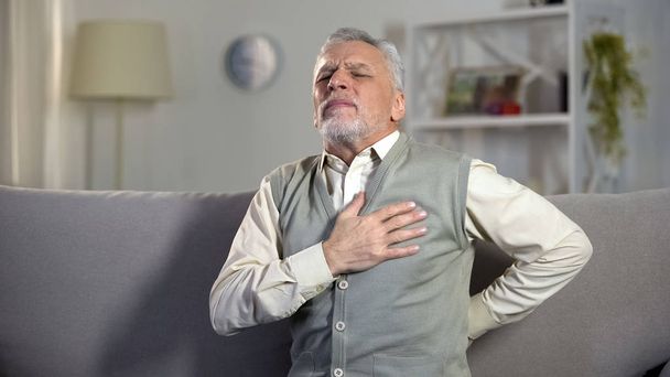 Elder man feeling sharp pain in chest and back, risk of heart attack, cardiology - Foto, Imagen