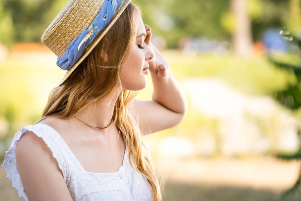 selective focus of beautiful girl in straw hat posing with closed eyes - Foto, Imagem