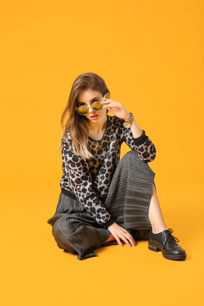 Fashionable young woman on color background - Foto, afbeelding