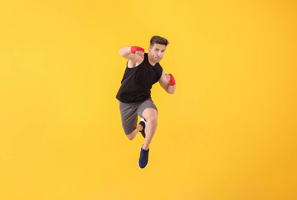 Sporty male kickboxer on color background - Foto, Bild