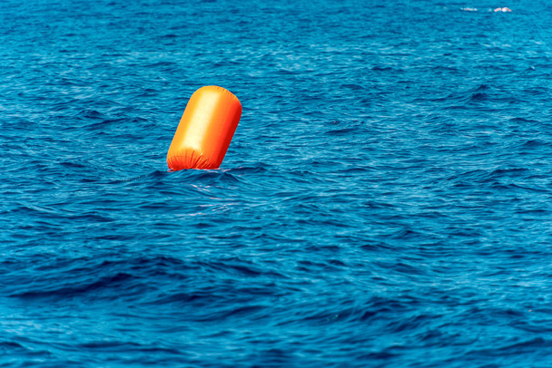 海の大きいオレンジ色の膨脹可能な信号ブイ - 写真・画像