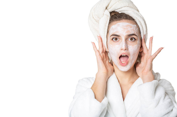 Podekscytowany brunetka dziewczyna z maską nawilżający i ręcznik kąpielowy na h - Zdjęcie, obraz