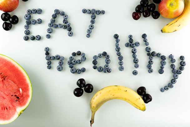 красочные полезные фрукты и ягоды с текстом "Ешьте здоровое" письмо
 - Фото, изображение