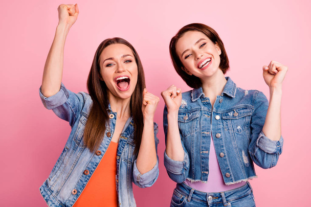 Close up photo two beautiful funky sisters she her yelling ladies pretty appearance party chill mood celebrate champions fists raised wear jeans denim jackets blazers isolated bright pink background - Photo, Image